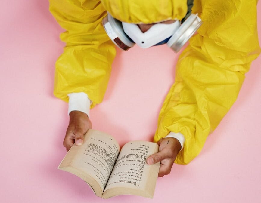Person in protective gear reading a book on education for protected persons.