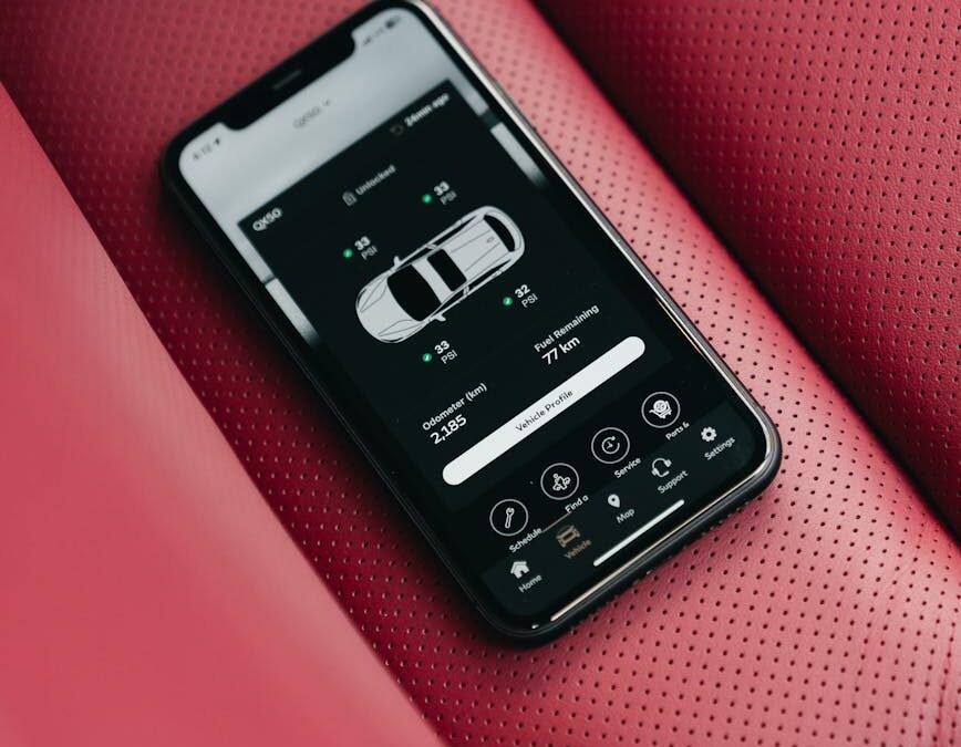 Smartphone displaying travel app features on luxurious car interior seat.