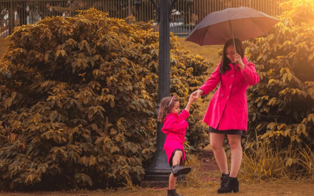 Mother and daughter in pink coats enjoying a day out, promoting sponsor daughter relationships.