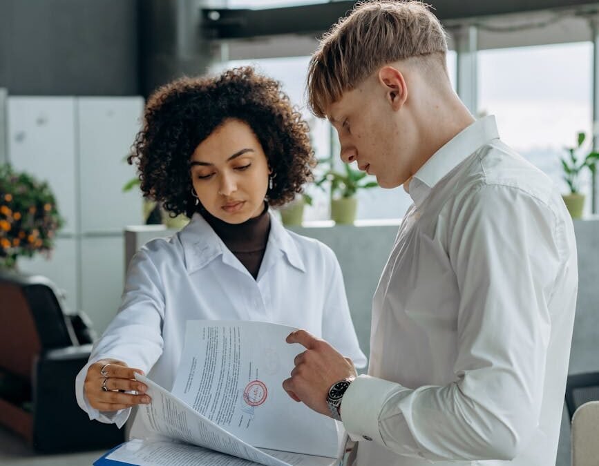 Two professionals discussing documents related to a Canadian work permit.
