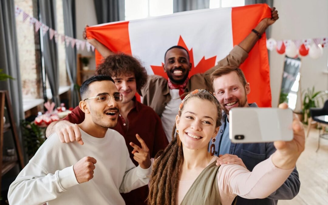 Diverse international students celebrating in Canada with a flag and taking a selfie.