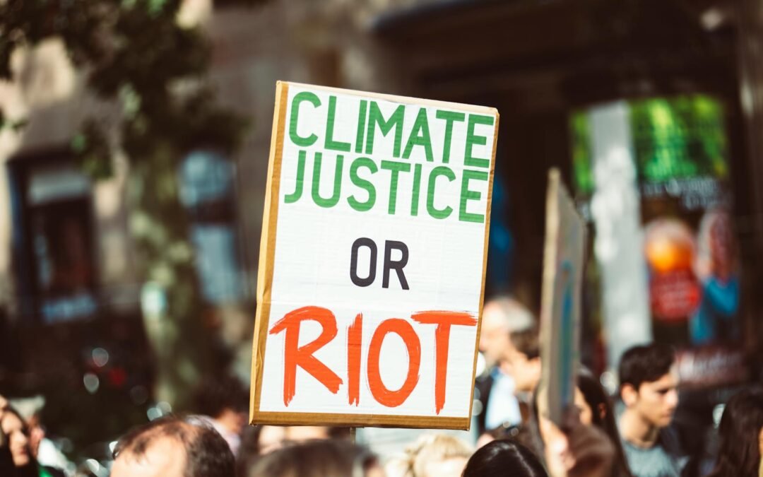 Protesters hold sign advocating for climate justice amidst climate change activism.