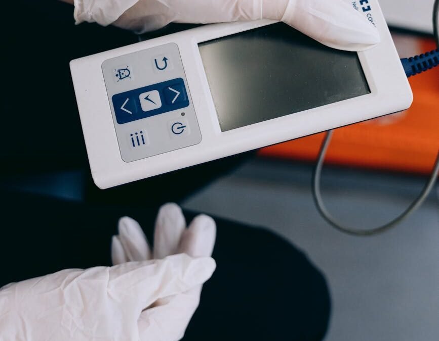 Person in gloves holding a modern healthcare device for patient monitoring and diagnostics.