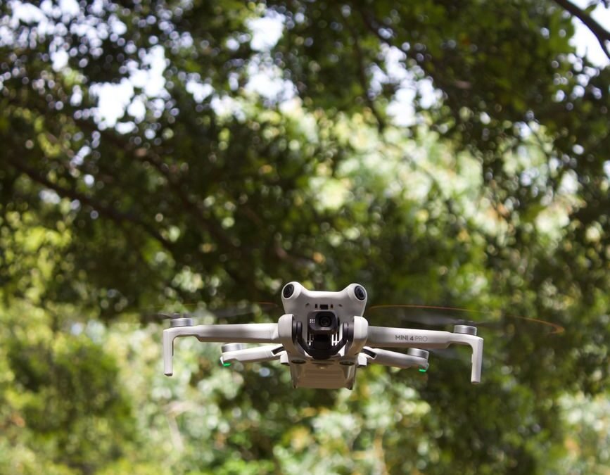 Drone flying amidst greenery, showcasing technological innovation in urban Canadian landscapes.