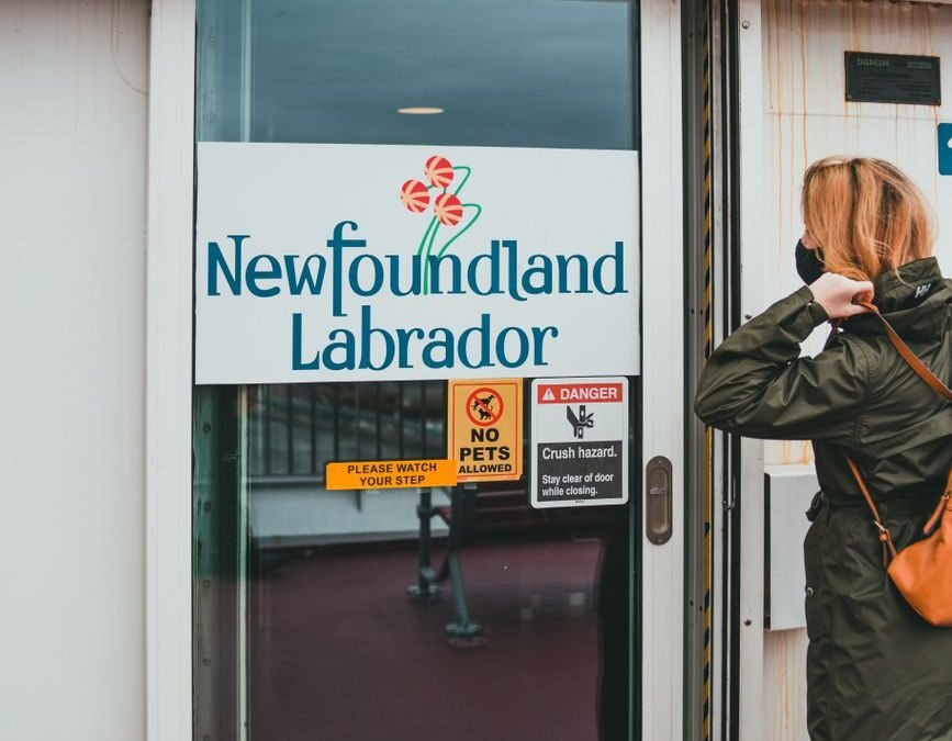Newfoundland and Labrador door sign, related to NLPNP invitations for immigration.